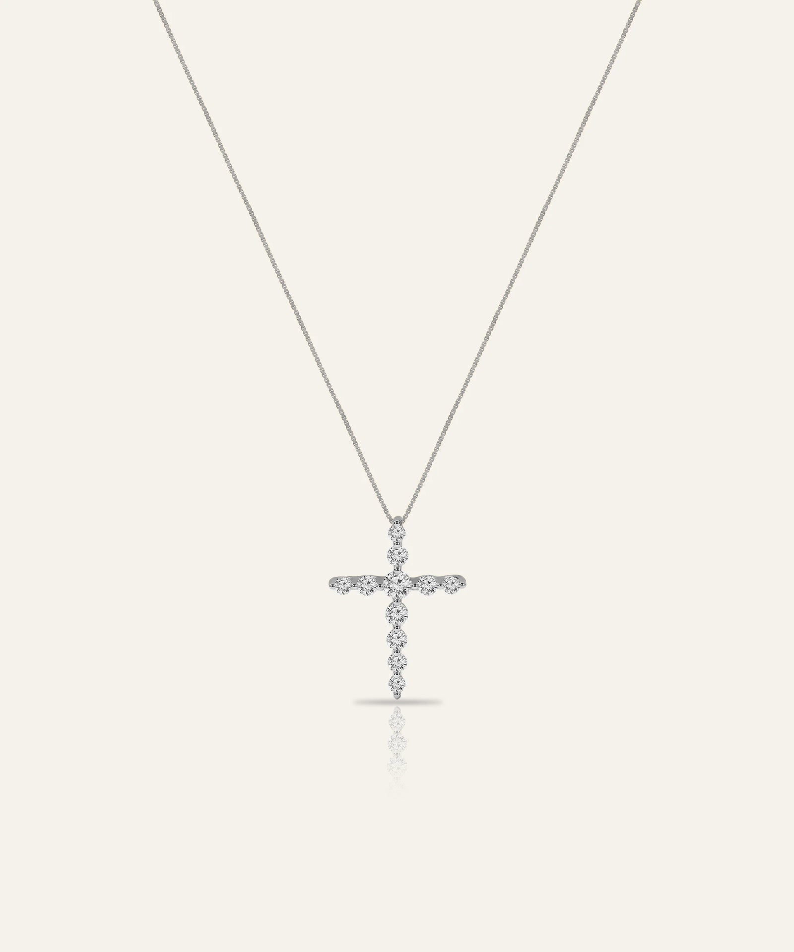Silver cross pendant necklace on a white background