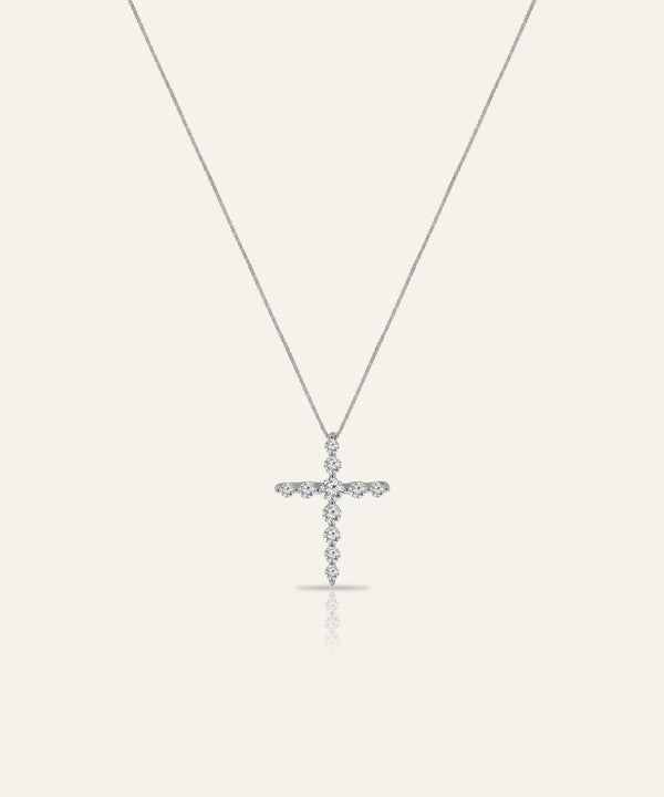 Silver cross pendant necklace on a white background