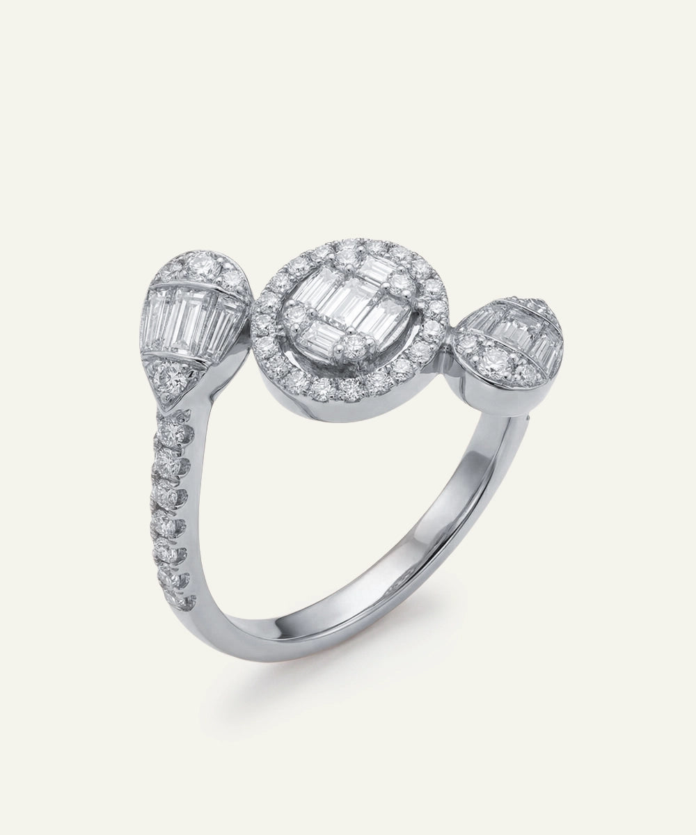 Diamond ring with three distinct gemstones on a light gray background