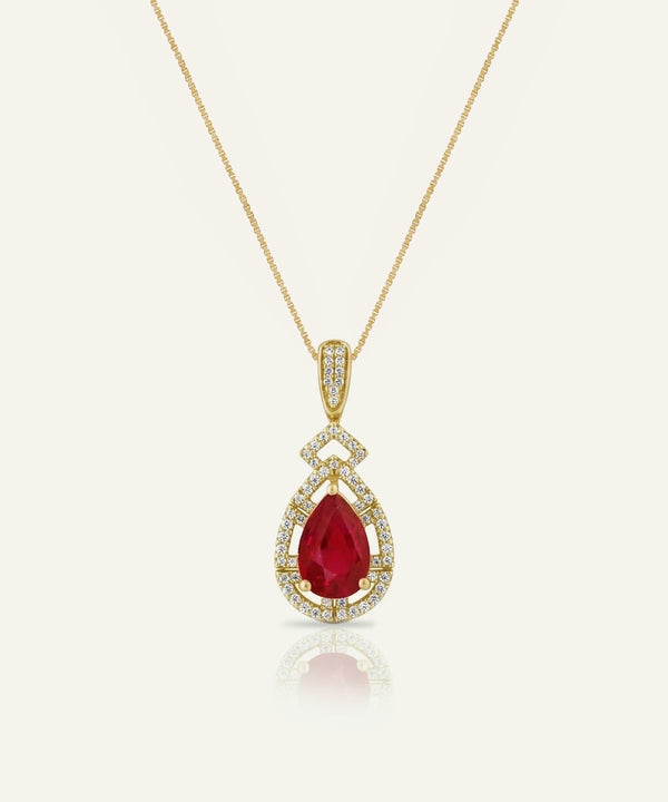 Gold pendant with a red gemstone on a white background