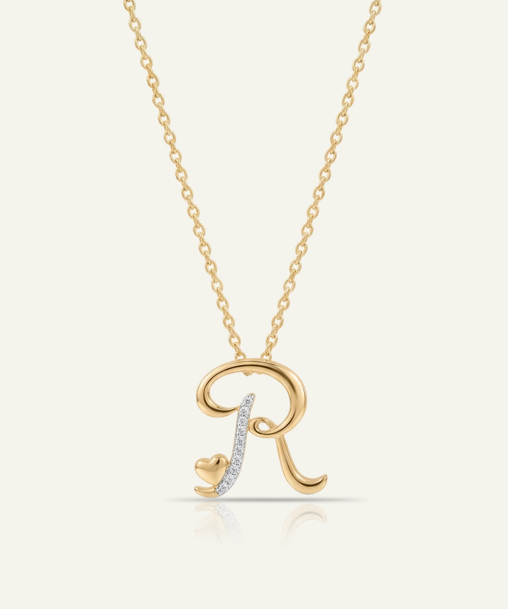 Gold necklace with a letter 'R' pendant on a light beige background