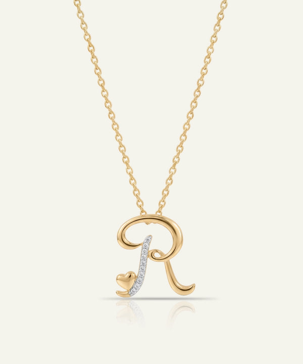 Gold necklace with a letter 'R' pendant on a light beige background