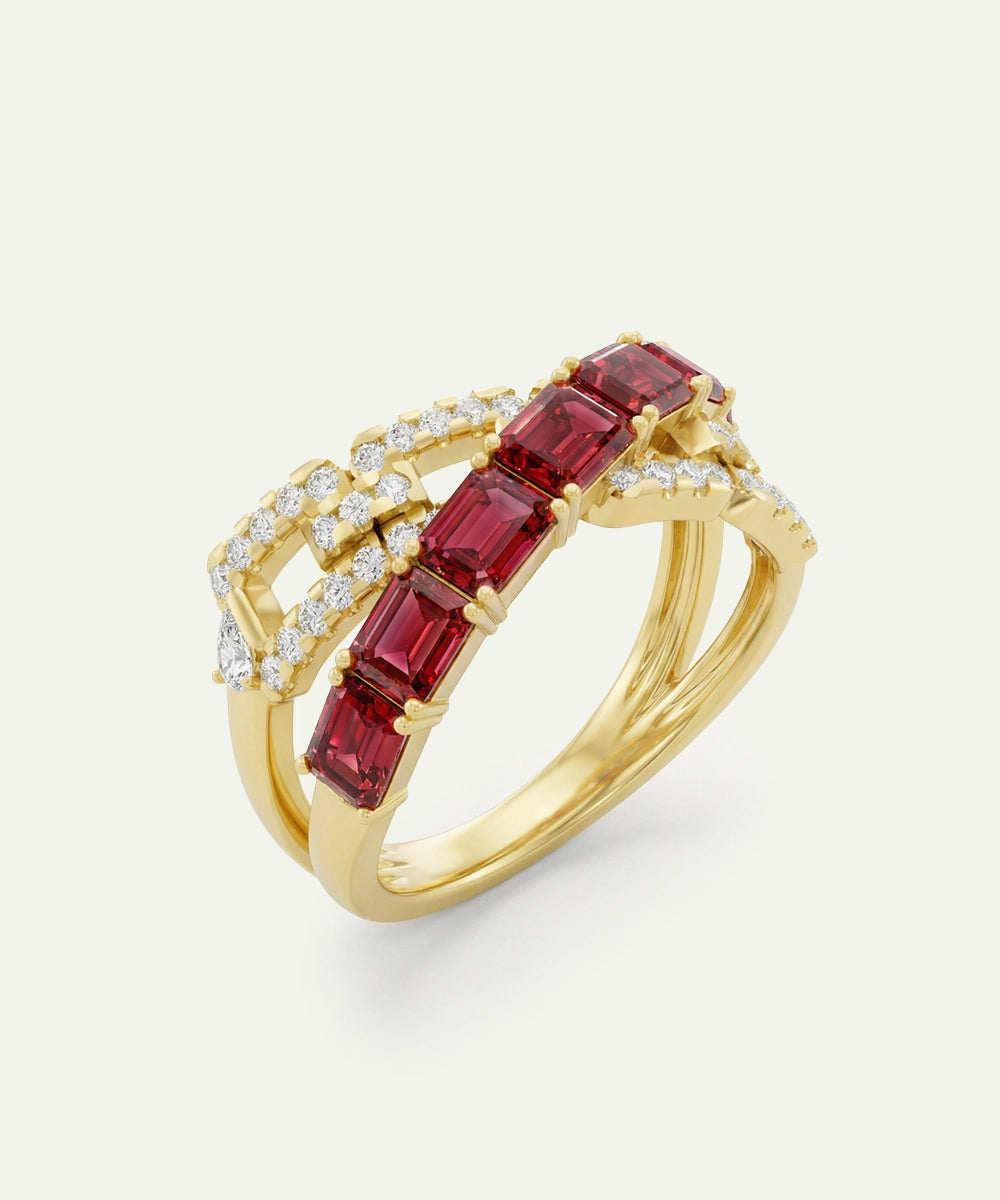 Gold ring with red gemstones and diamonds on a light gray background