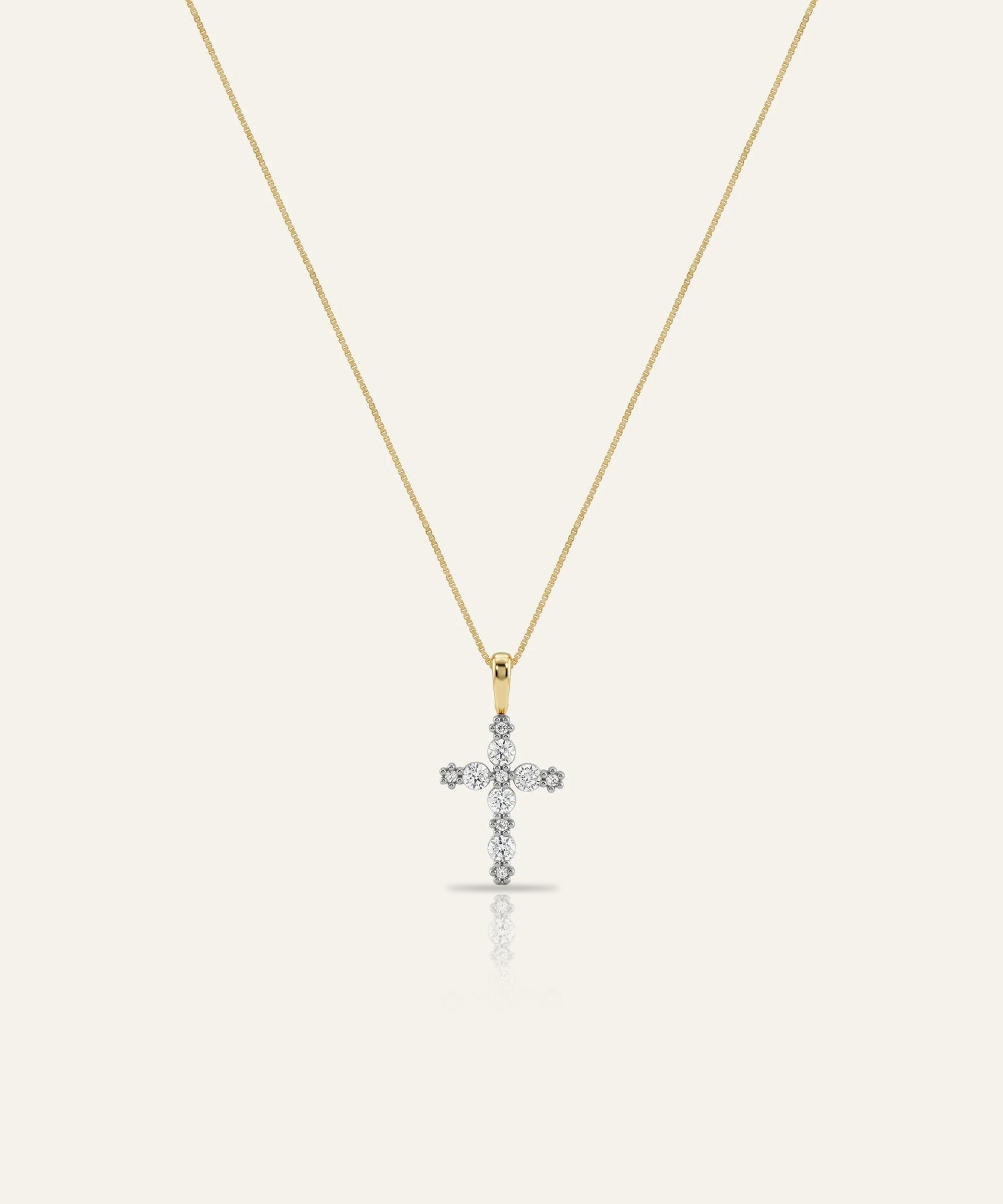 Gold necklace with a diamond cross pendant on a white background
