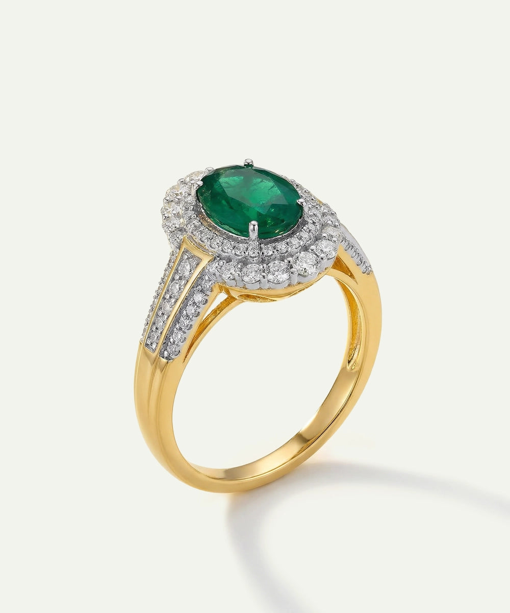 Gold ring with a green gemstone and diamond accents on a white background