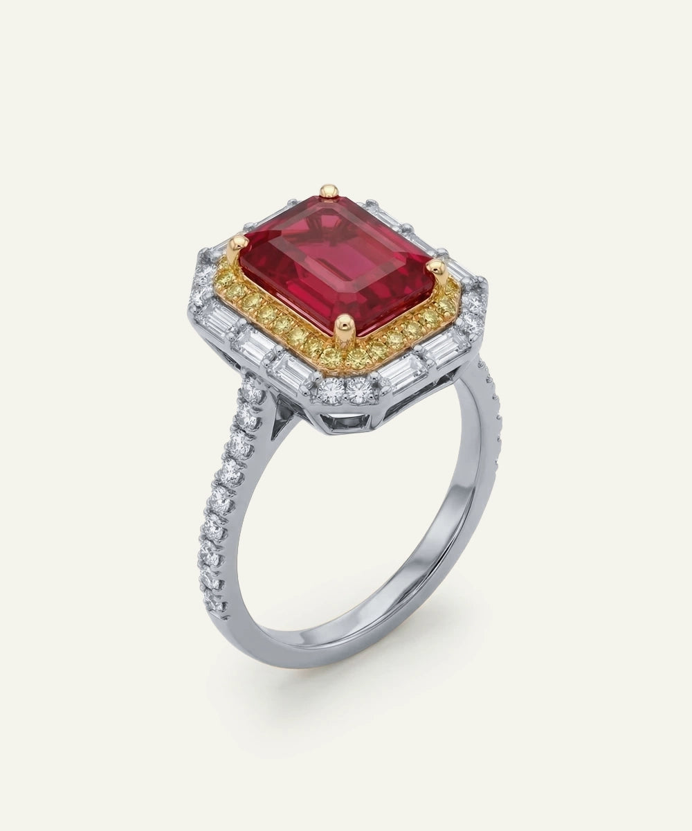 Ring with a red gemstone and diamond accents on a white background