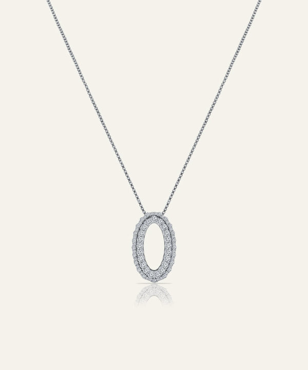 Silver necklace with a round pendant on a light gray background