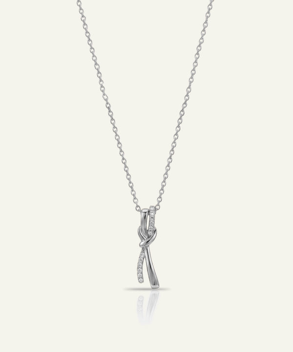 Silver necklace with a bow-shaped pendant on a white background