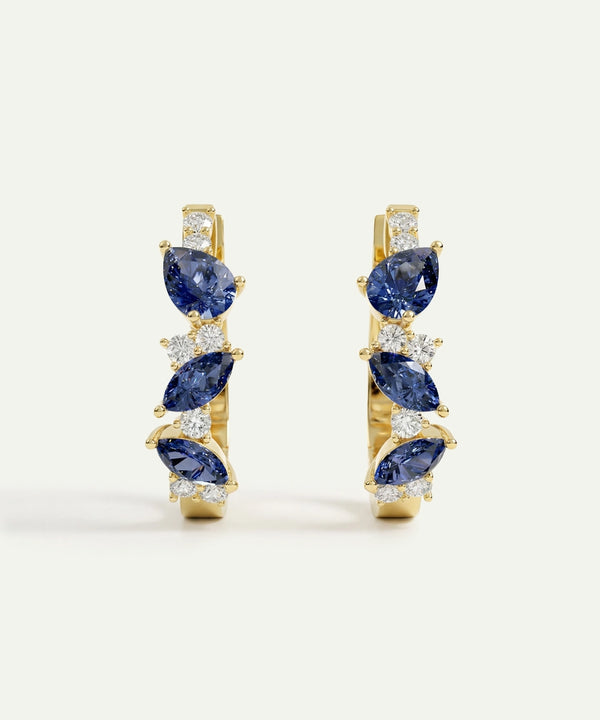 Pair of gold earrings with blue gemstones on a white background