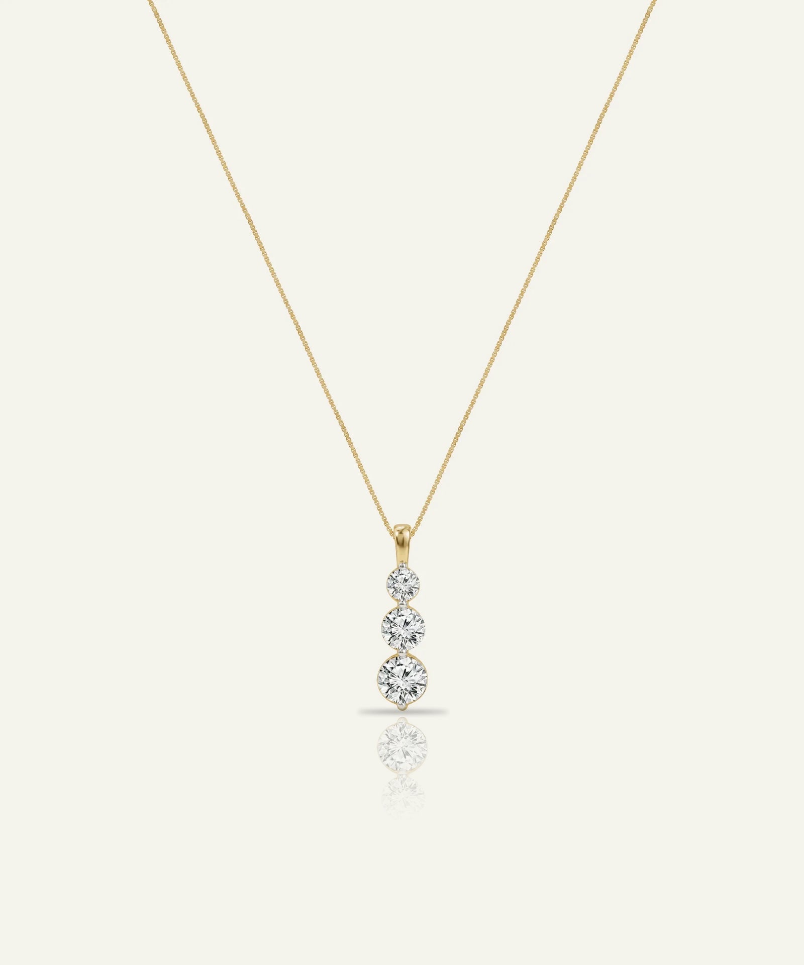 Gold necklace with a diamond pendant on a white background