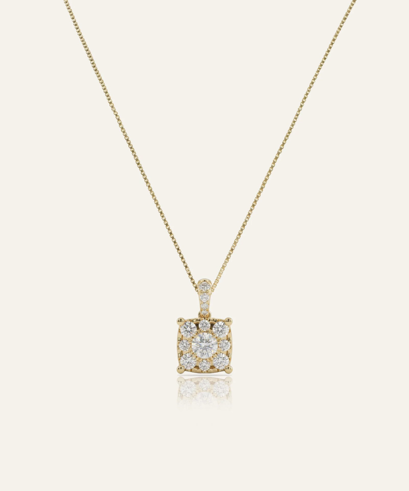 Gold necklace with a square diamond pendant on a light beige background