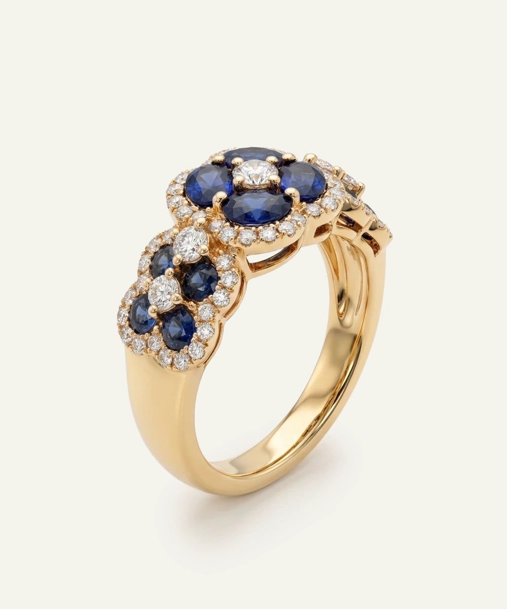 Gold ring with blue gemstones and diamonds on a white background