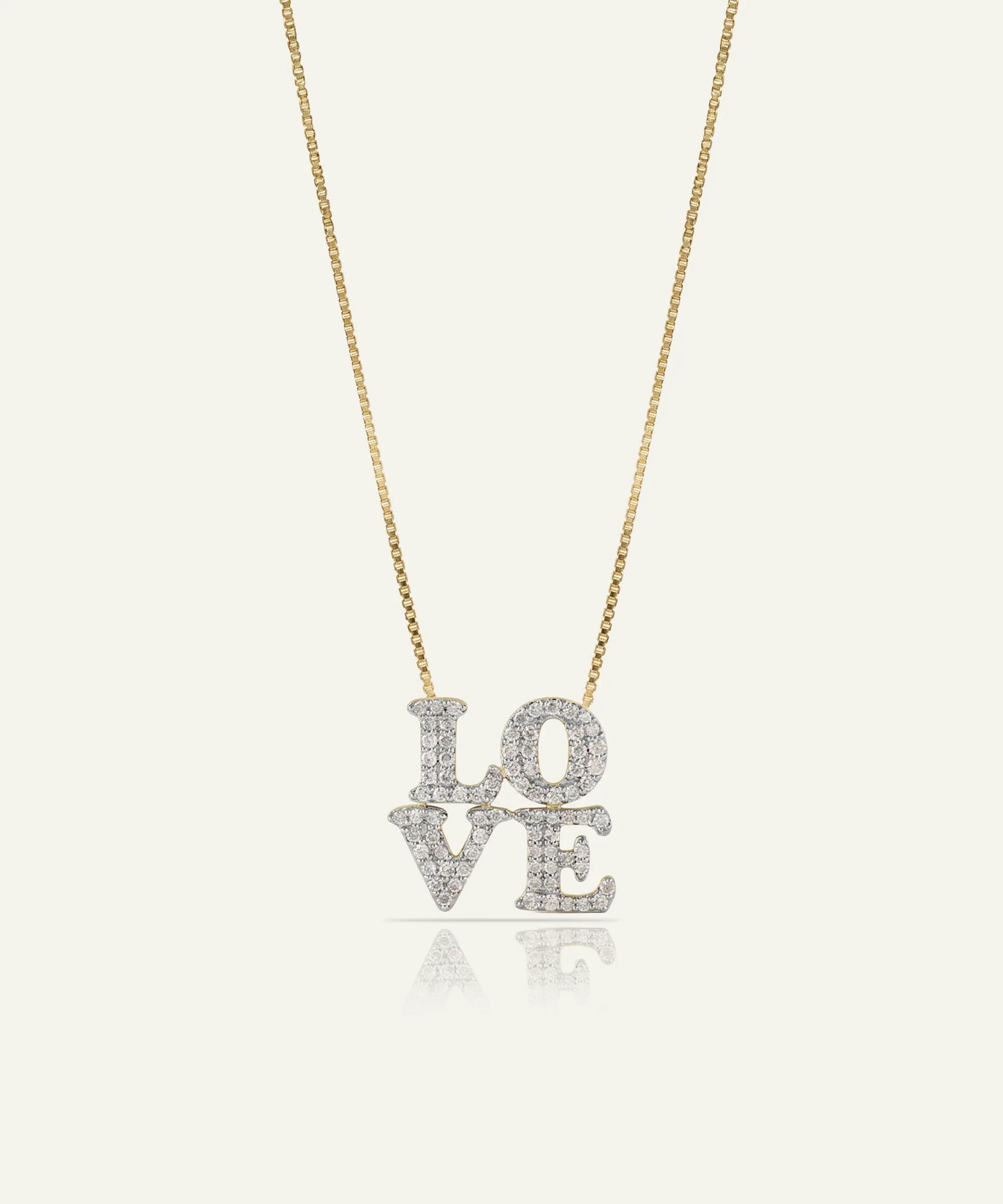 Gold necklace with a heart-shaped pendant on a light gray background