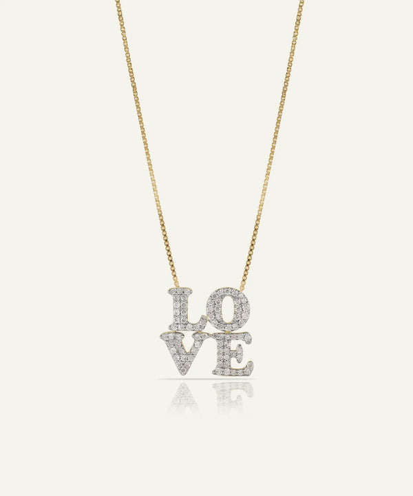 Gold necklace with a heart-shaped pendant on a light gray background