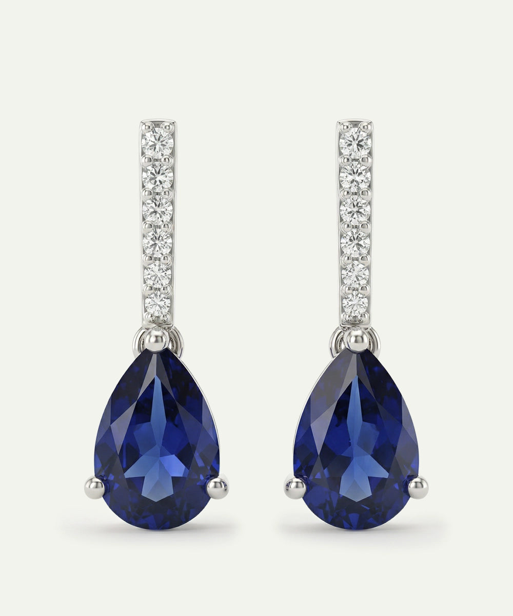 Pair of blue teardrop earrings with silver accents on a white background