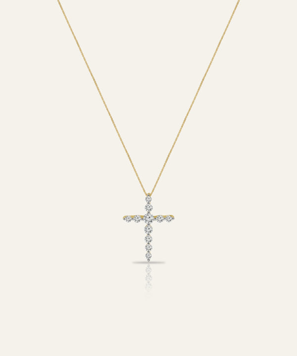 Gold cross necklace with diamonds on a white background
