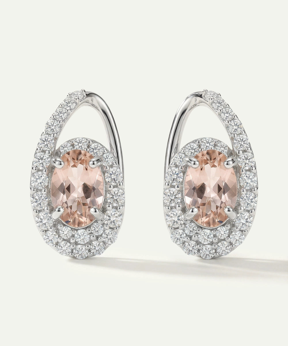 Pair of earrings with pink gemstones and diamond accents on a white background