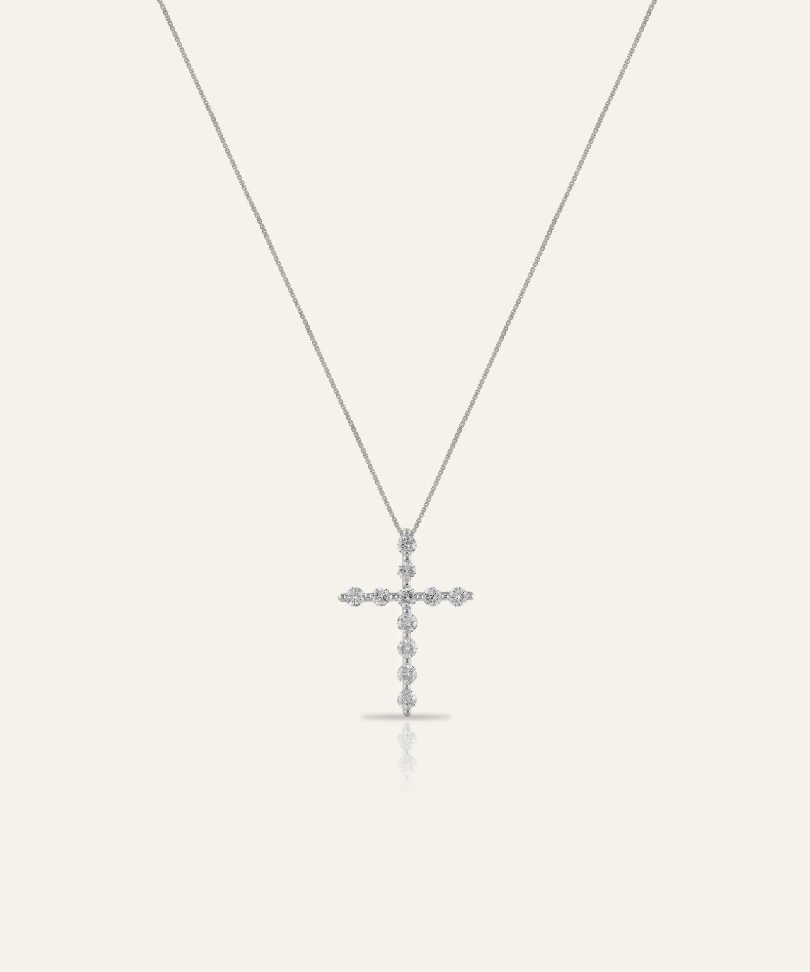 Silver cross pendant necklace on a white background