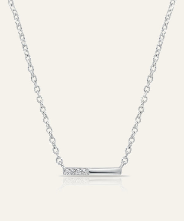 Silver necklace with a bar pendant on a light gray background