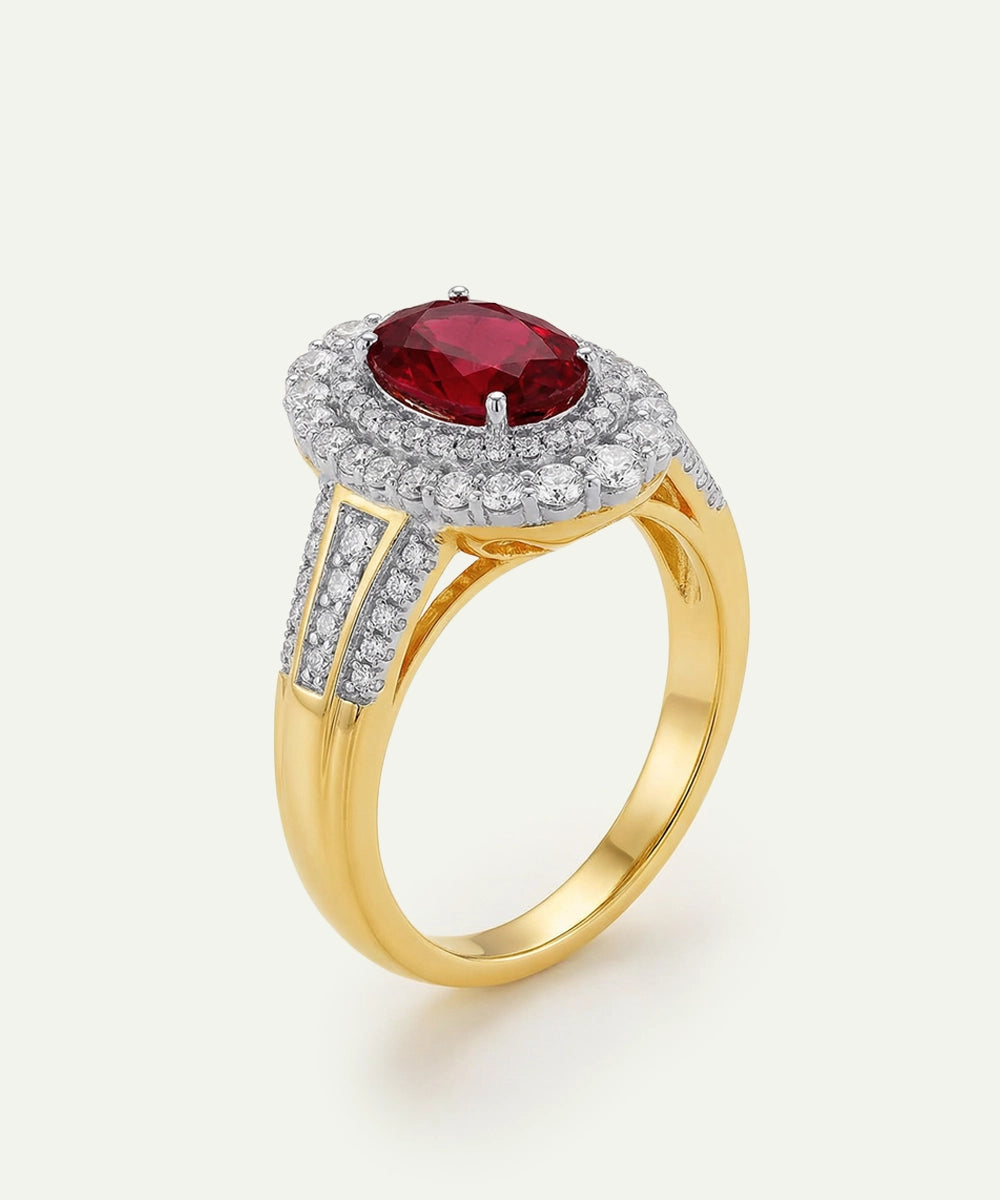 Gold ring with a red gemstone and diamond accents on a white background