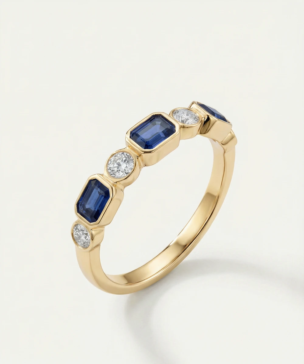 Gold ring with blue gemstones and diamonds on a light background