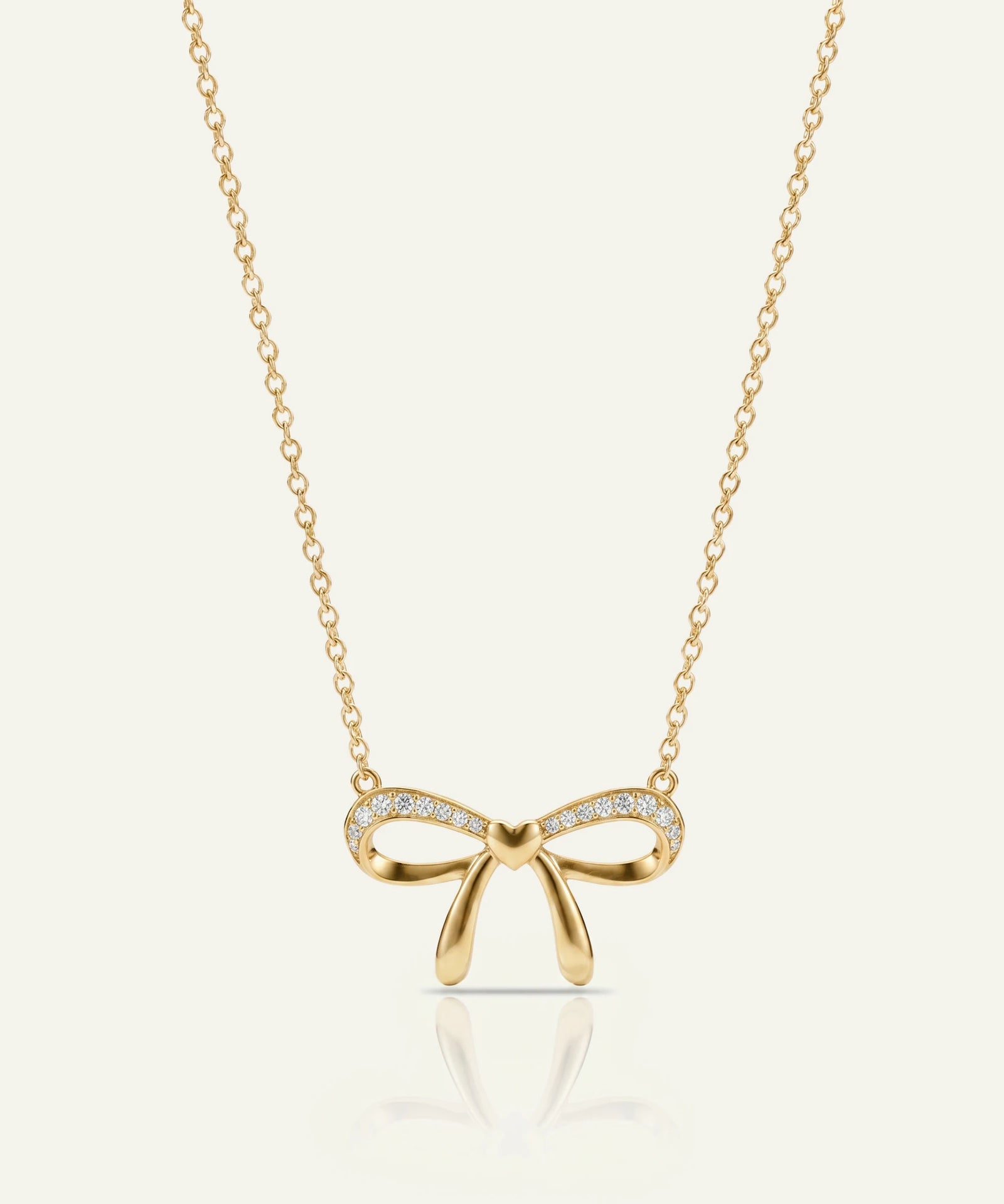 Gold bow-shaped necklace with diamonds on a white background