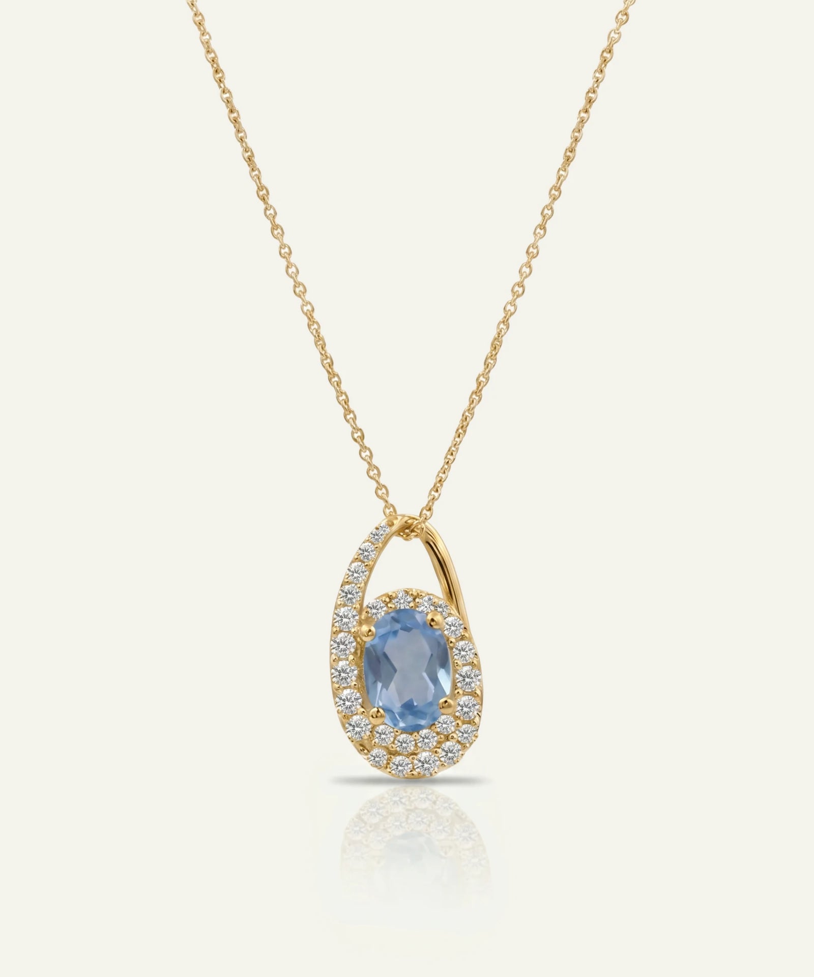 Gold necklace with a blue gemstone pendant on a white background