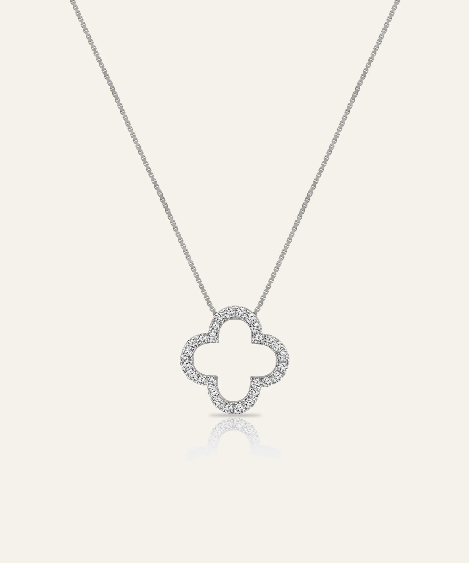 Silver necklace with a clover-shaped pendant on a light gray background