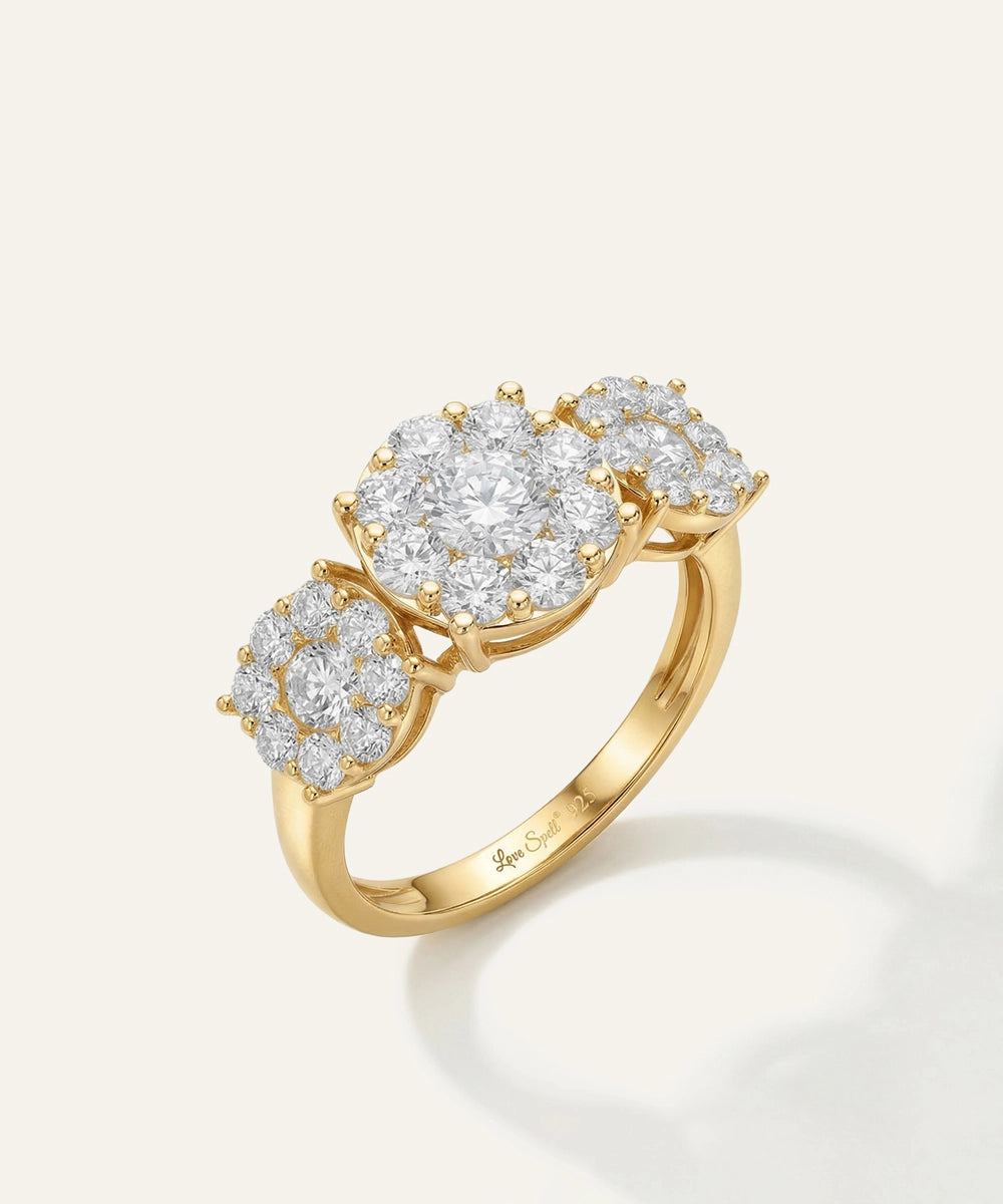 Gold ring with three circular diamond clusters on a light gray background