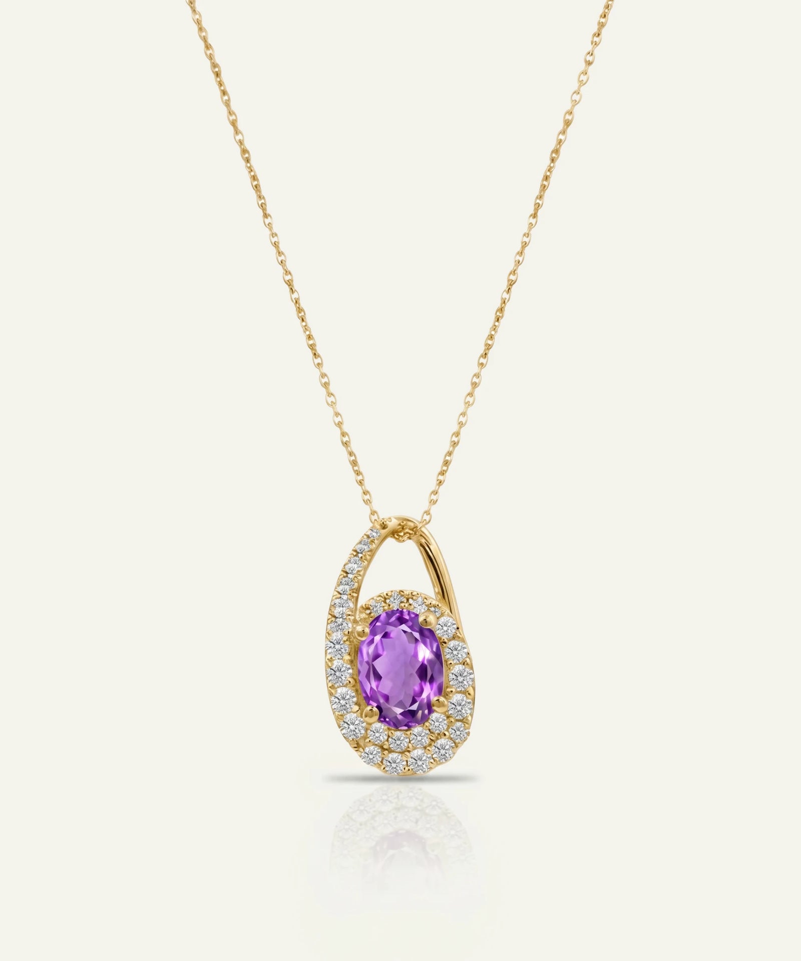 Gold necklace with a purple gemstone pendant on a white background