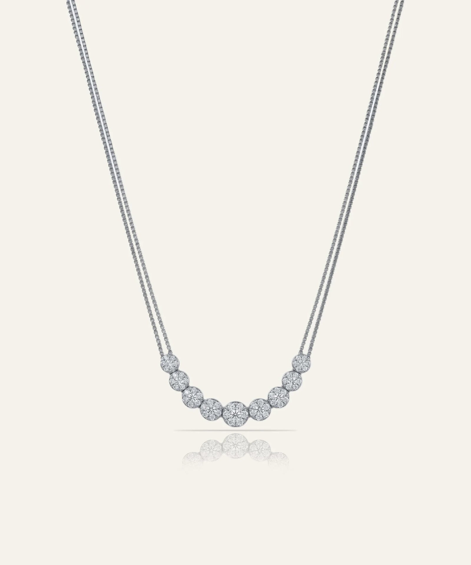 Silver necklace with small round beads on a light gray background