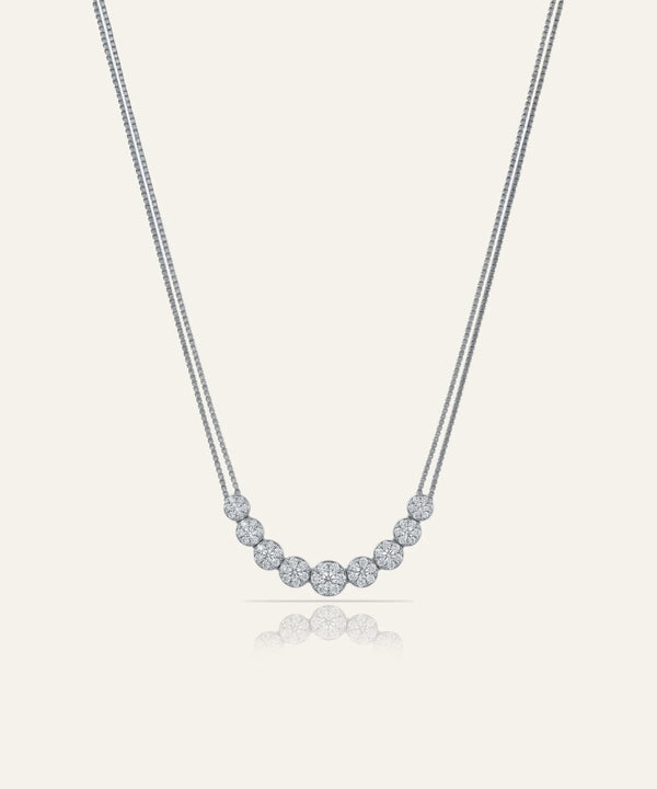 Silver necklace with small round beads on a light gray background