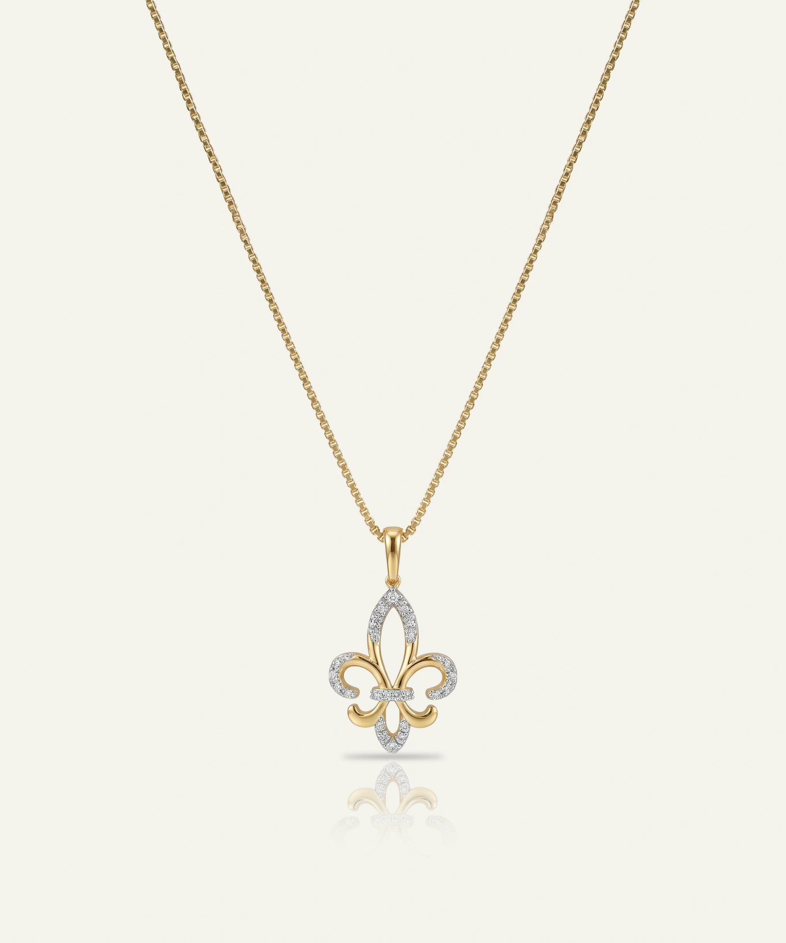 Gold and silver fleur-de-lis pendant on a chain against a white background