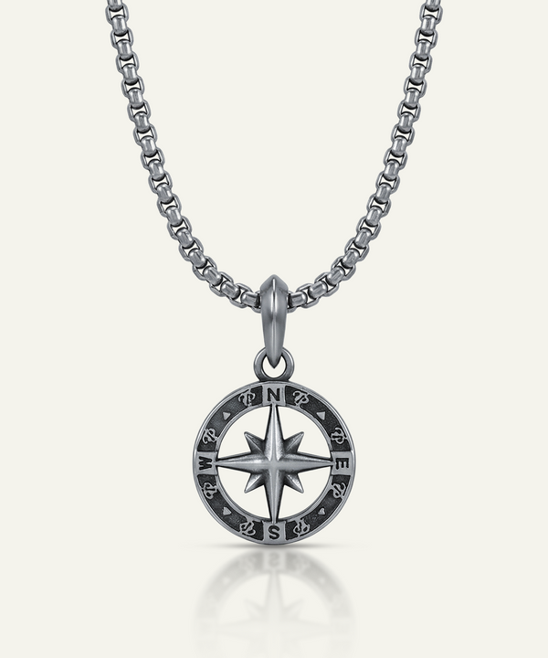 Silver compass necklace on a white background