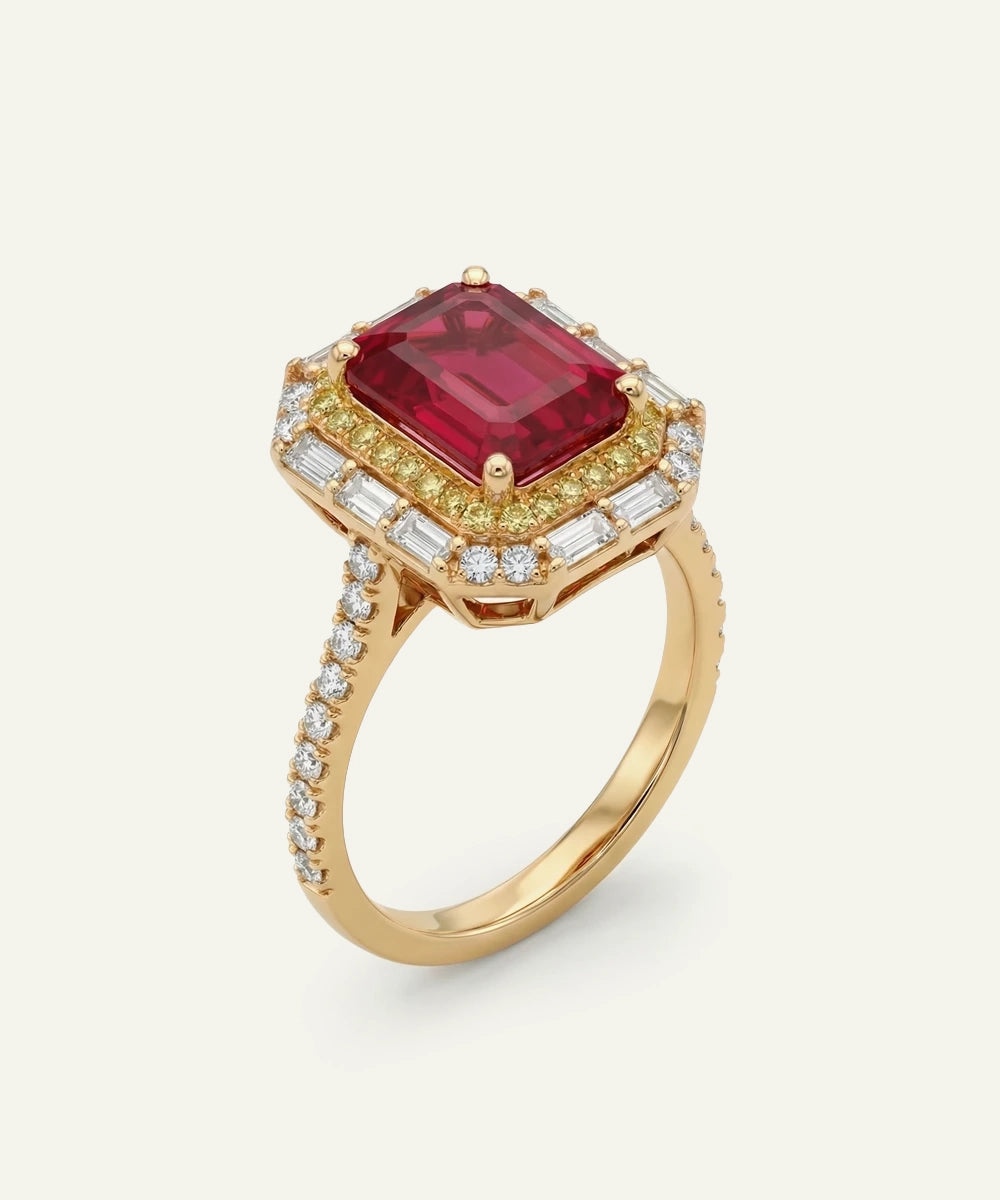 Gold ring with a red gemstone and diamond accents on a white background