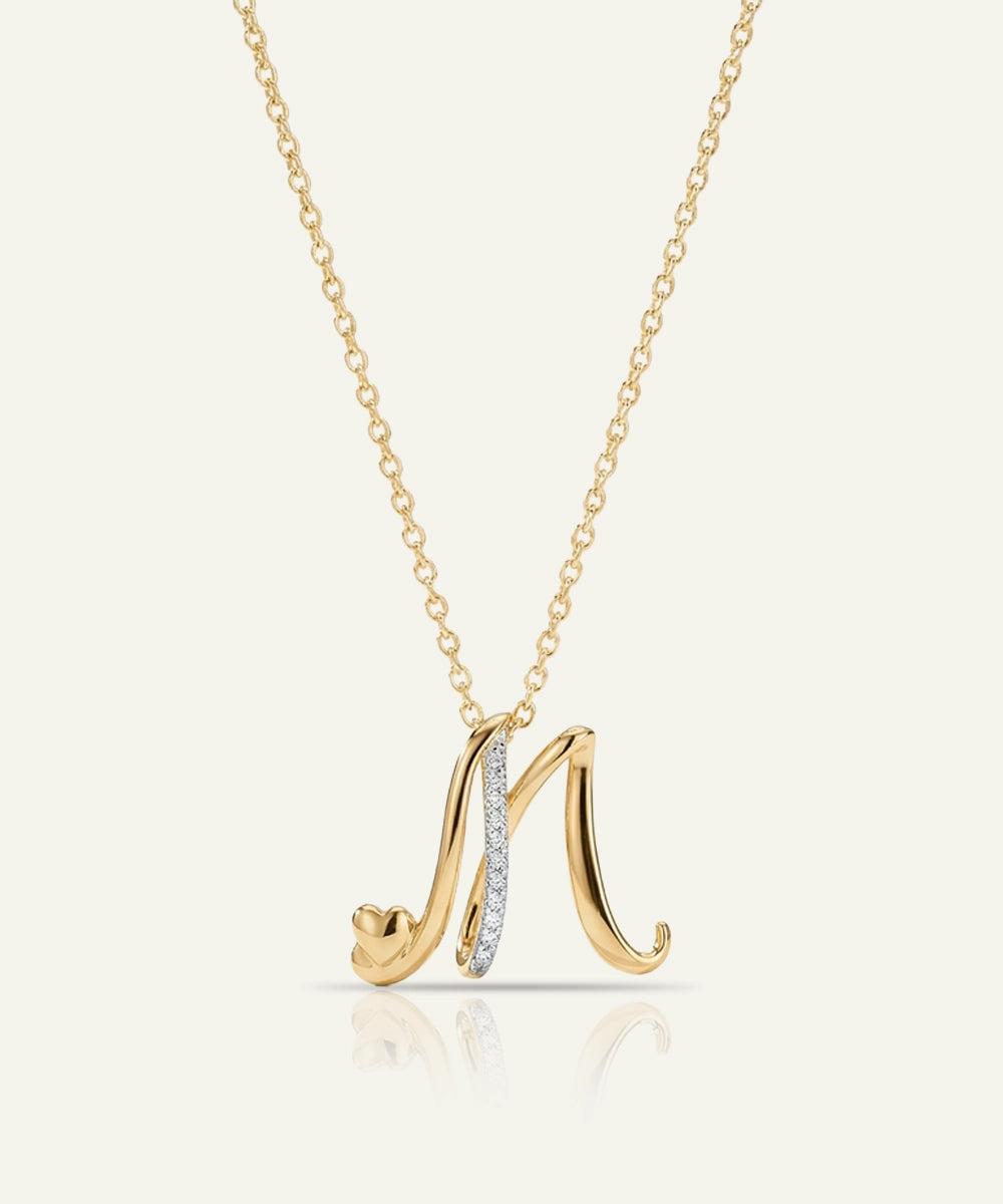 Gold necklace with a letter 'M' pendant on a white background