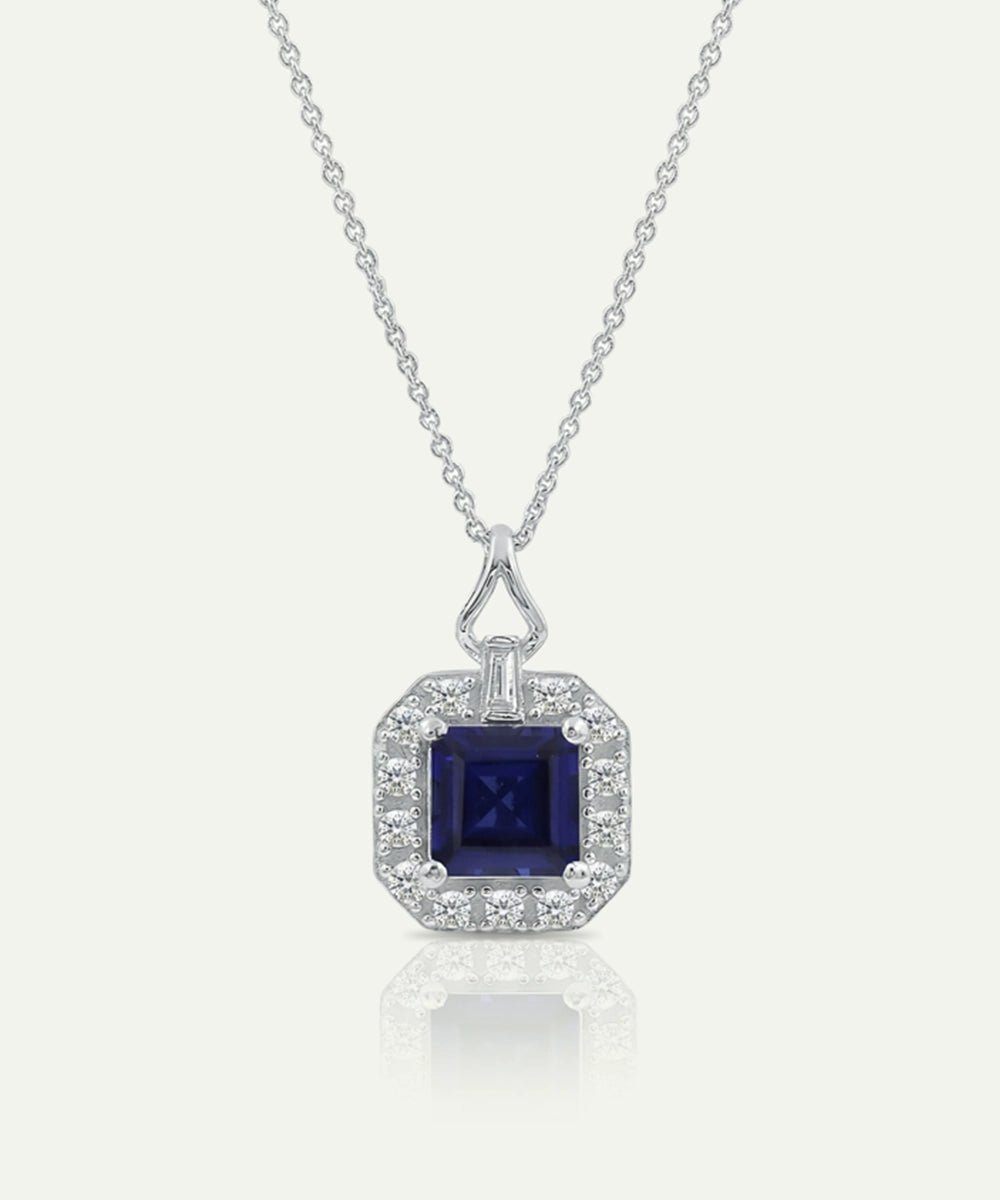 Silver necklace with a blue gemstone pendant on a white background