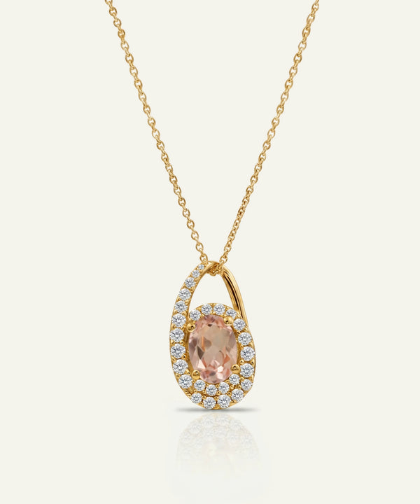 Gold necklace with a pendant featuring a pink gemstone on a white background