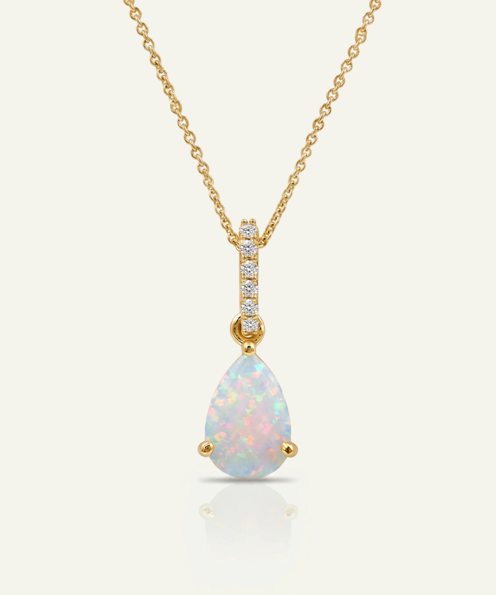 Opal teardrop pendant with gold chain on a white background
