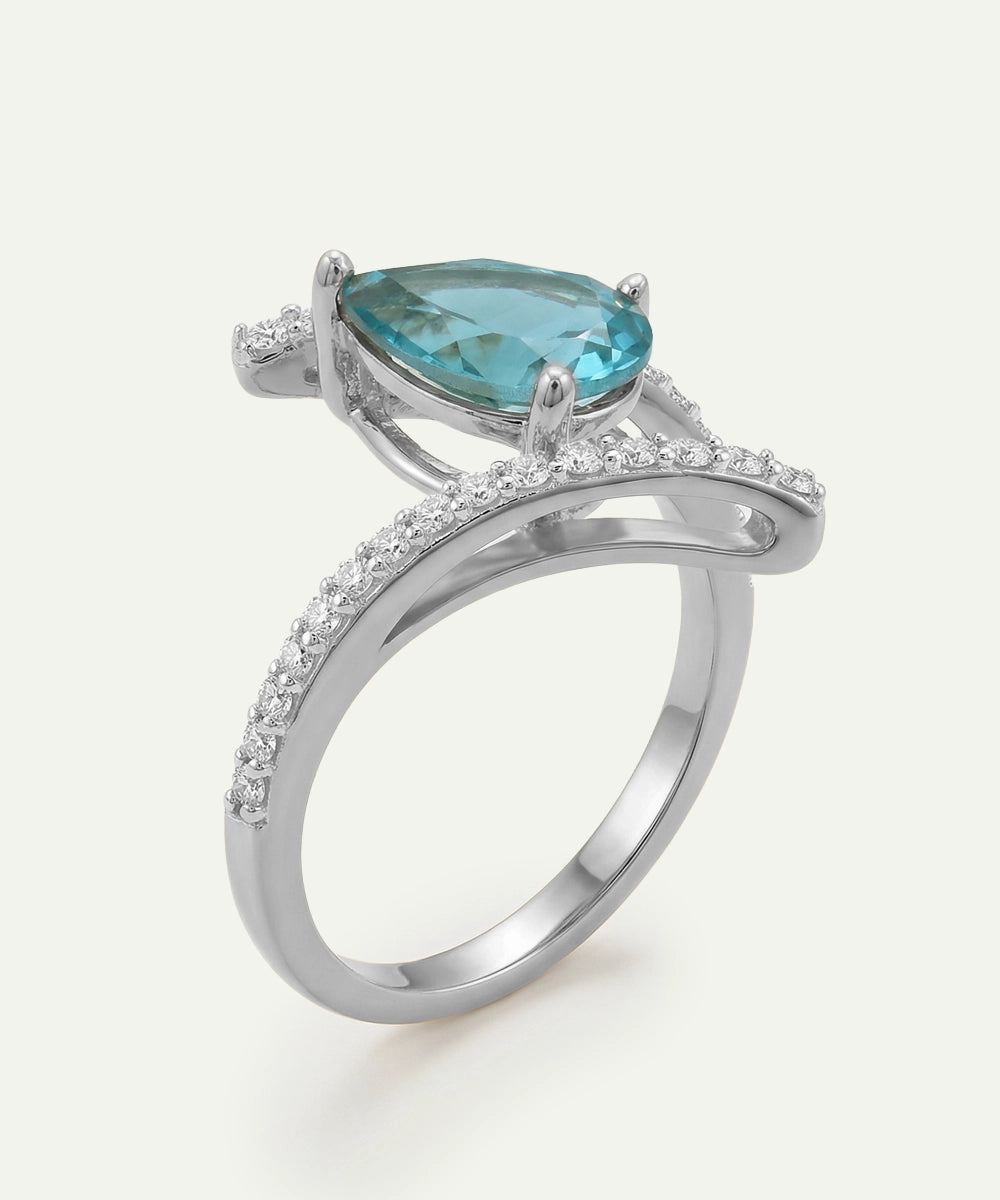 Silver ring with a pear-shaped blue gemstone on a white background