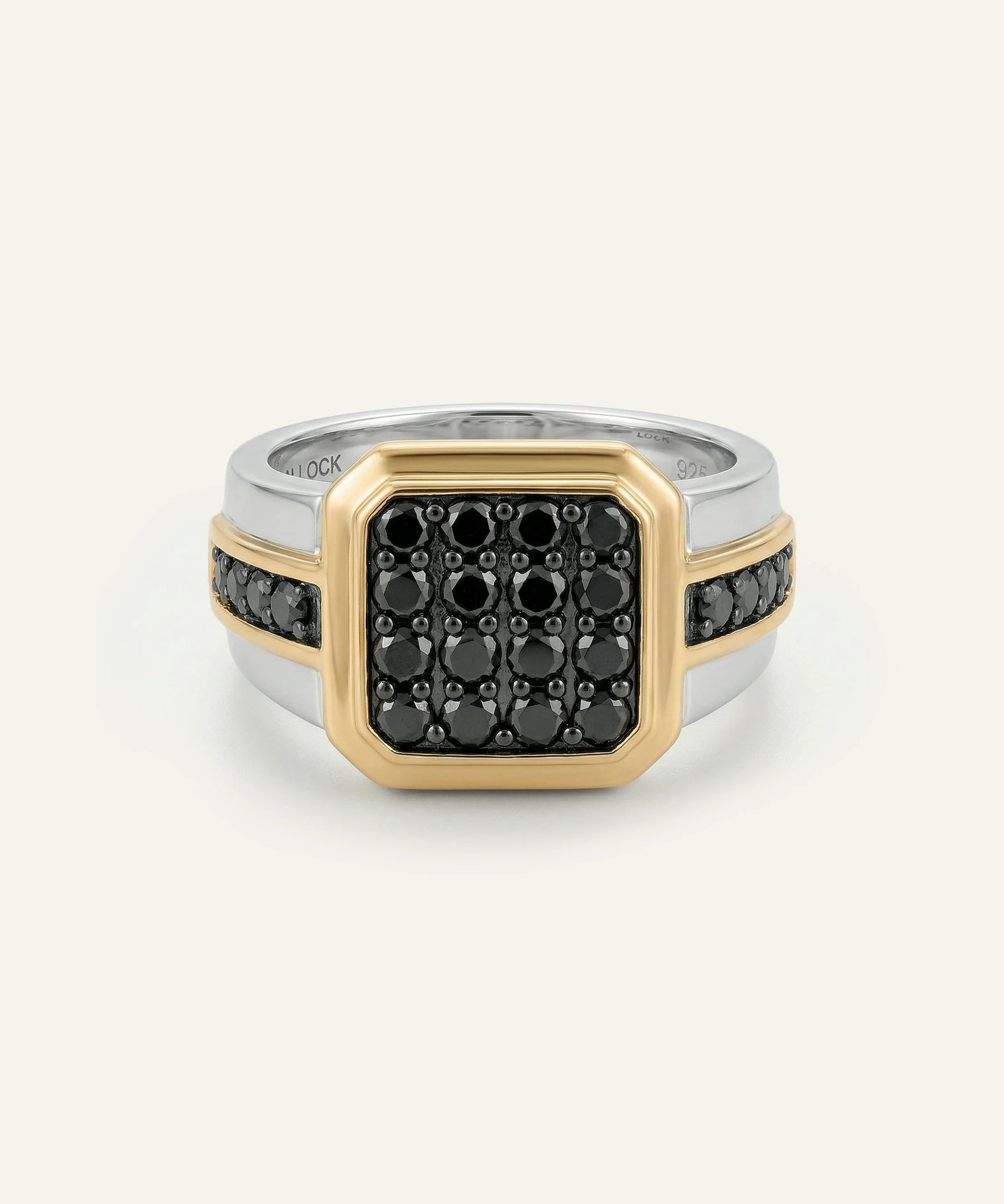 Two-tone ring with black gemstones on a white background