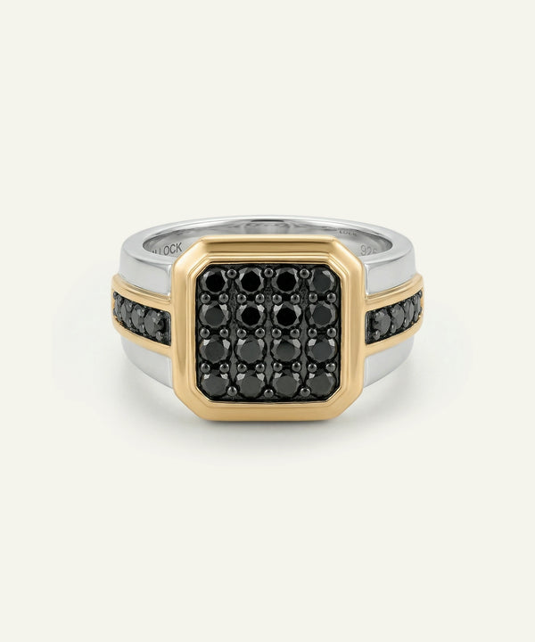 Two-tone ring with black gemstones on a white background