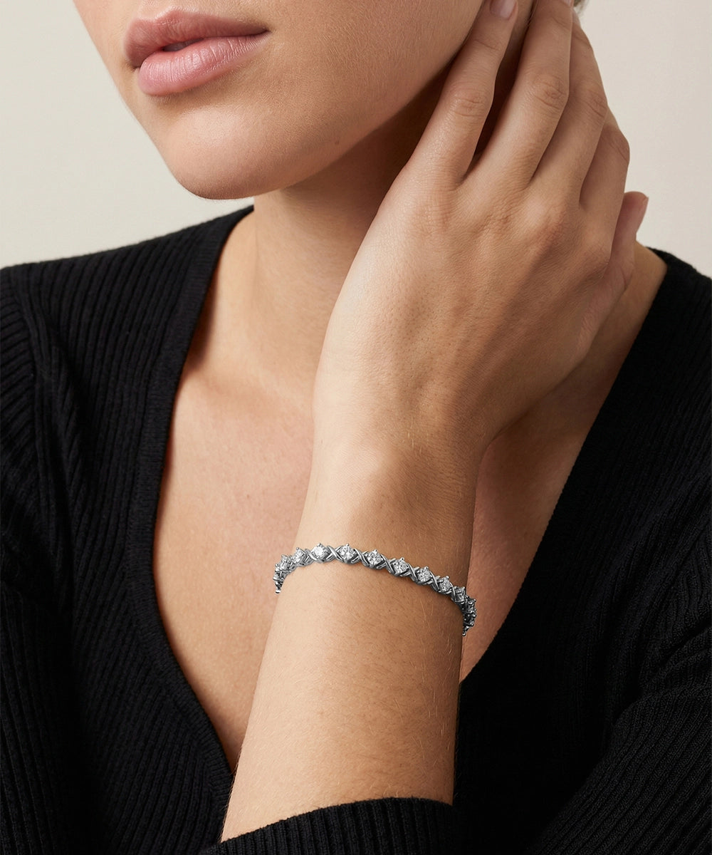 Close-up of a person wearing a silver bracelet on a neutral background