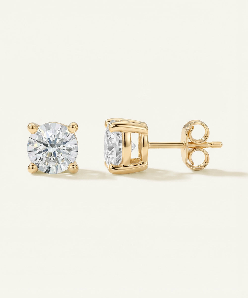 Gold stud earrings with clear gemstones on a white background