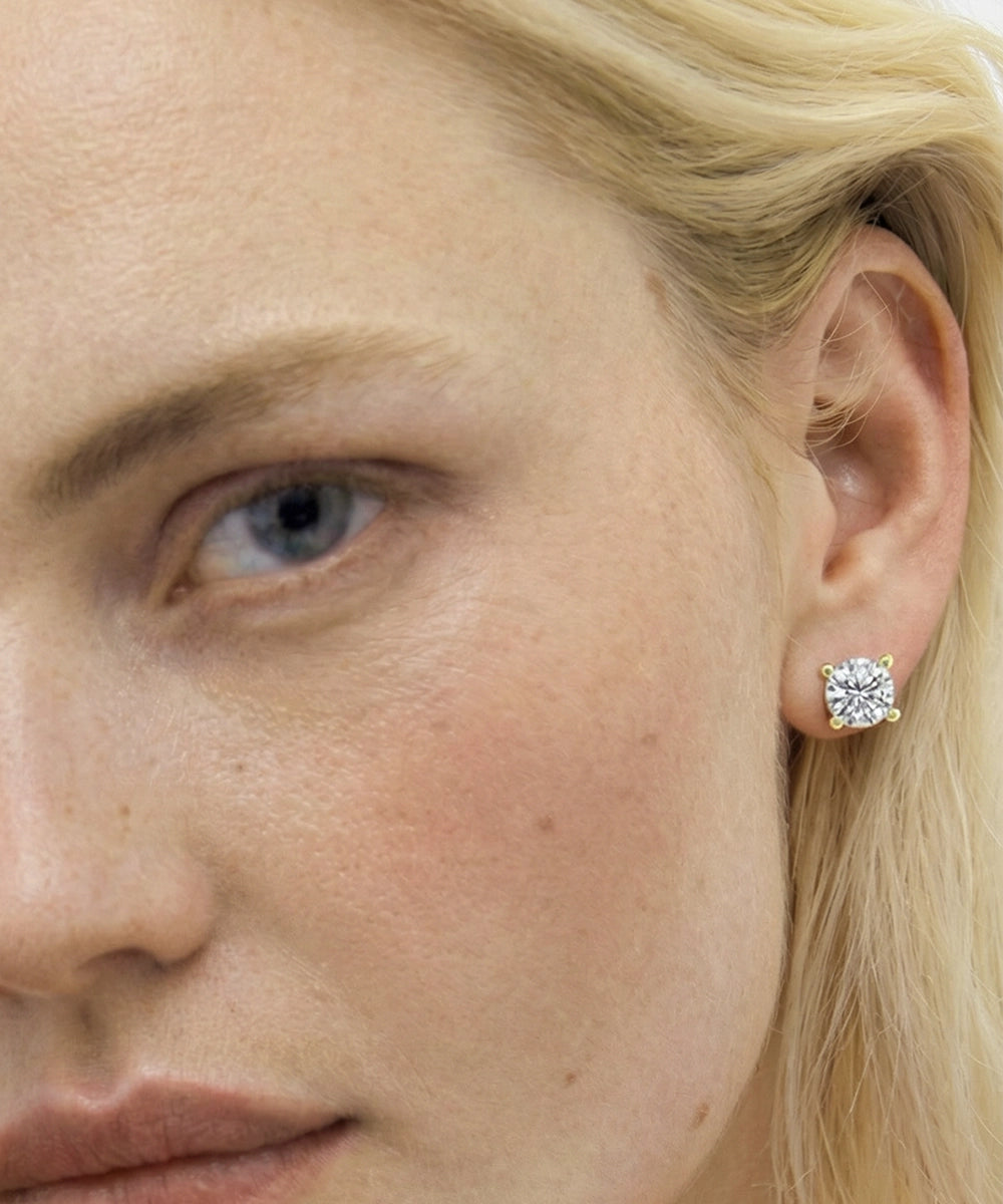 Close-up of a woman's face wearing a diamond earring.