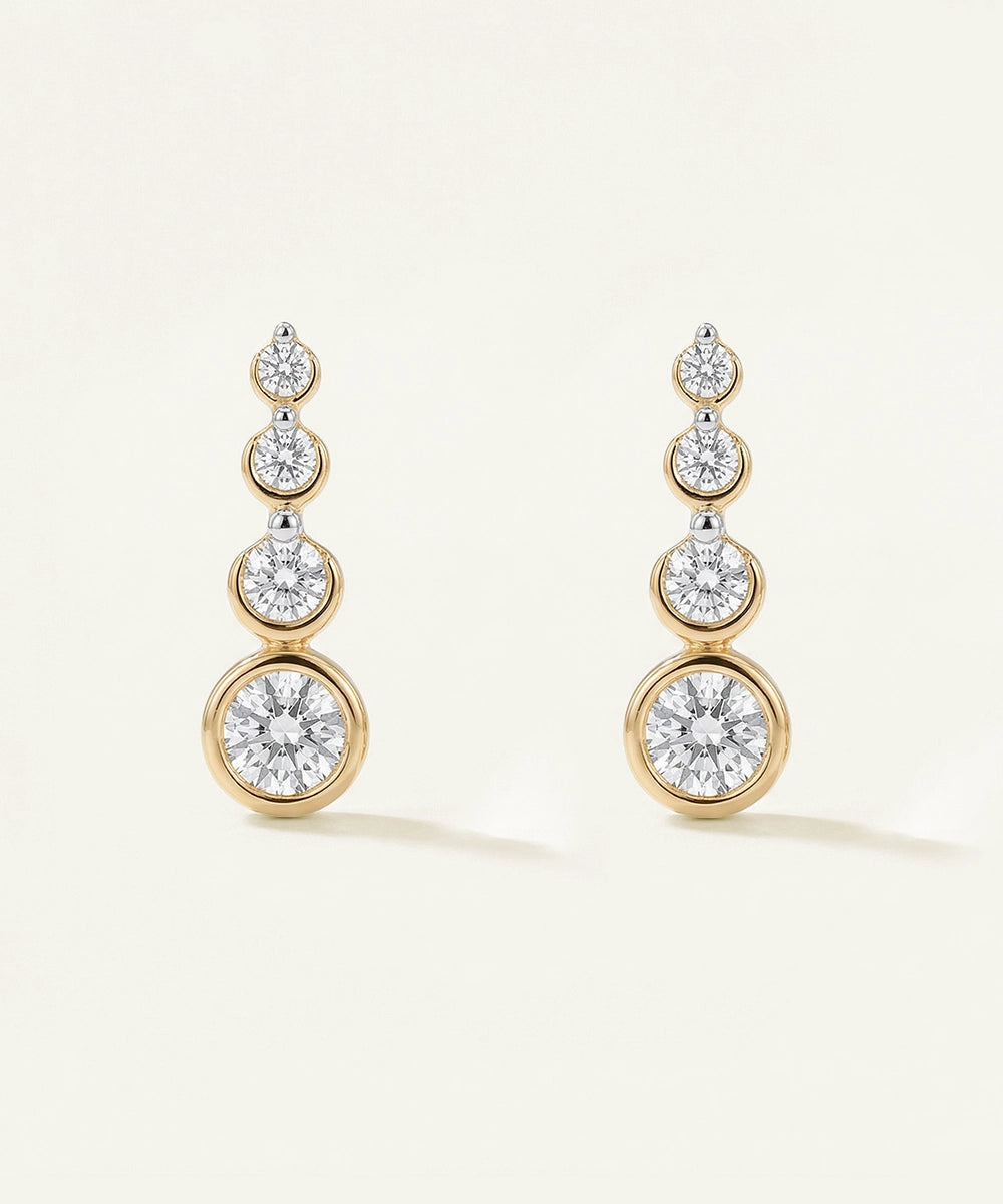 Gold and diamond earrings on a light beige background