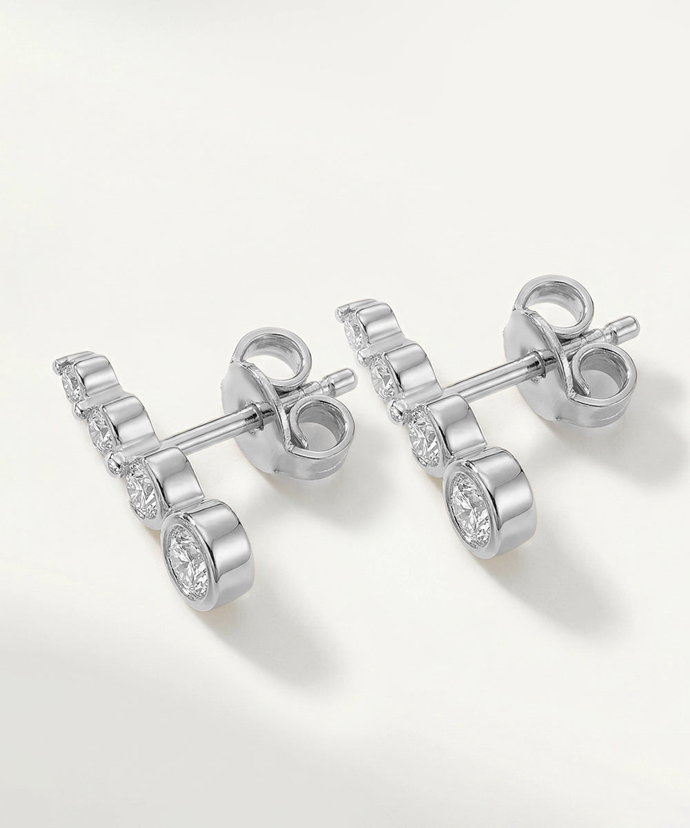 Silver earrings with clear gemstones on a white background