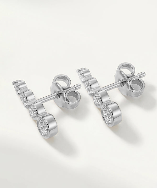 Silver earrings with clear gemstones on a white background