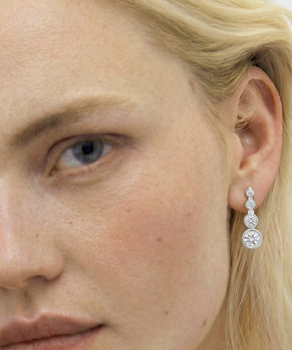 Close-up of a woman wearing a diamond earring.