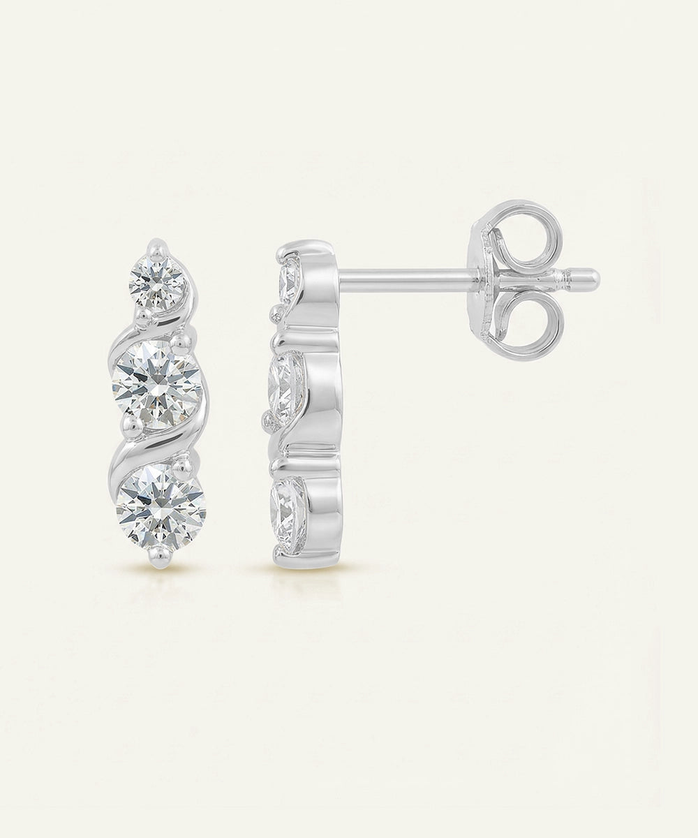 Pair of silver earrings with diamond-like stones on a white background